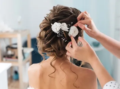 Coiffure de mariée avec des fleurs blanches, une personne l'ajuste à Valence dans le Tarn-et-Garonne 82