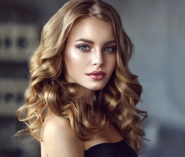 Jeune femme aux longs cheveux blonds ondulés, vêtue d'un haut noir à Valence dans le Tarn-et-Garonne 82